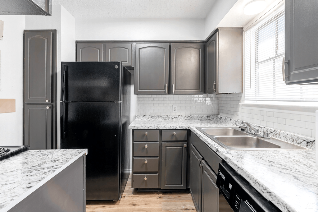 a kitchen with gray cabinets and white countertops