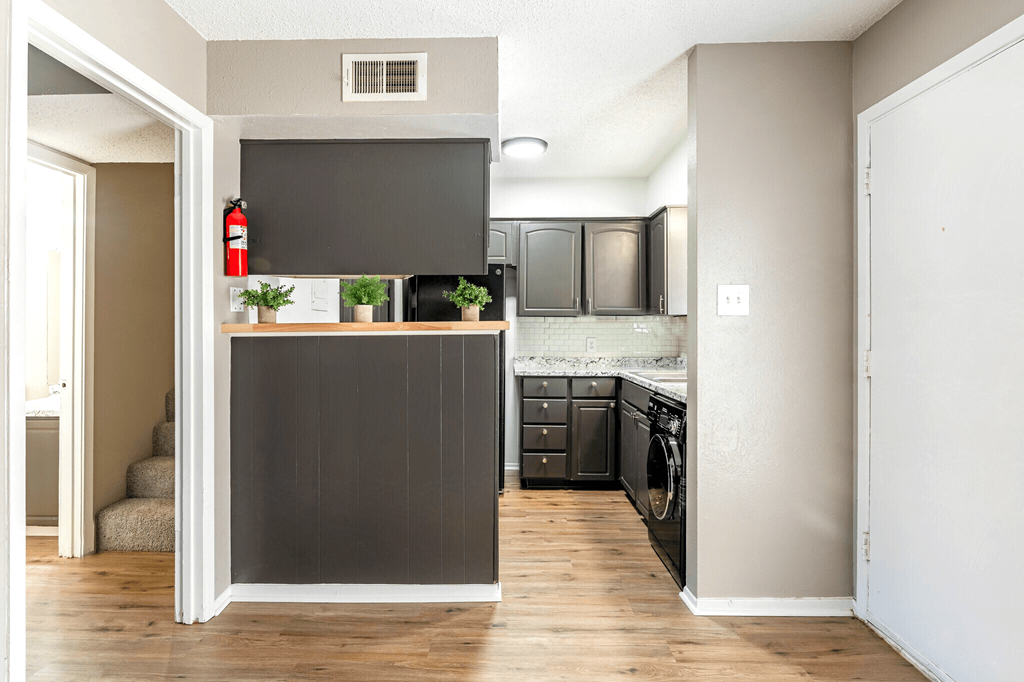 a small kitchen with black cabinets and a fire extinguisher on the counter