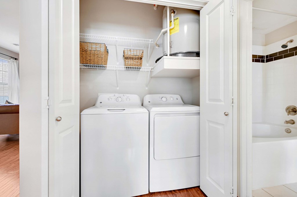 a white laundry room with two washes and a dryer