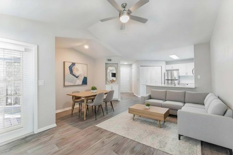 A living room with a grey couch, a wooden coffee table, and a painting on the wall.