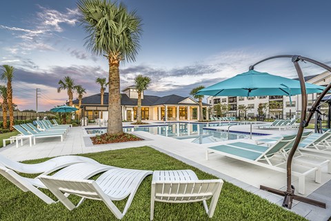 a swimming pool with lounge chairs and umbrellas at the resort