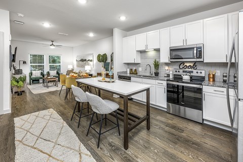 an open kitchen and living room with a table and chairs
