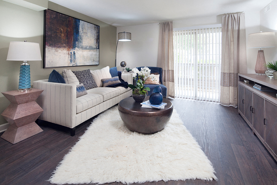 Ardenne Apartment living room with white rug, couch and sliding glass doors to outside