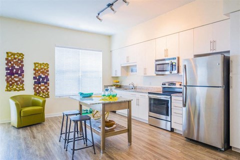 A kitchen with a table and chairs and a refrigerator.