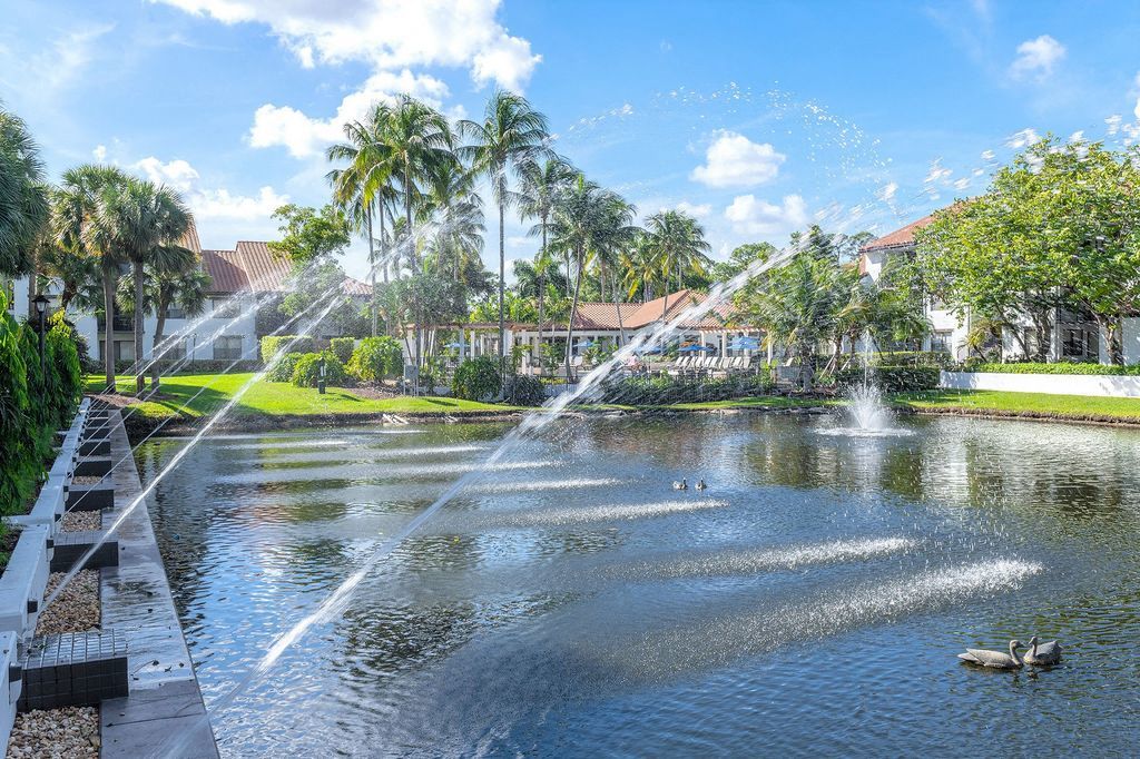 Streams of water from fountain jetting up from left to enter lake on right
