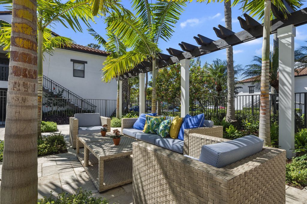 Outdoor sitting area with couch, two chairs, and coffee table