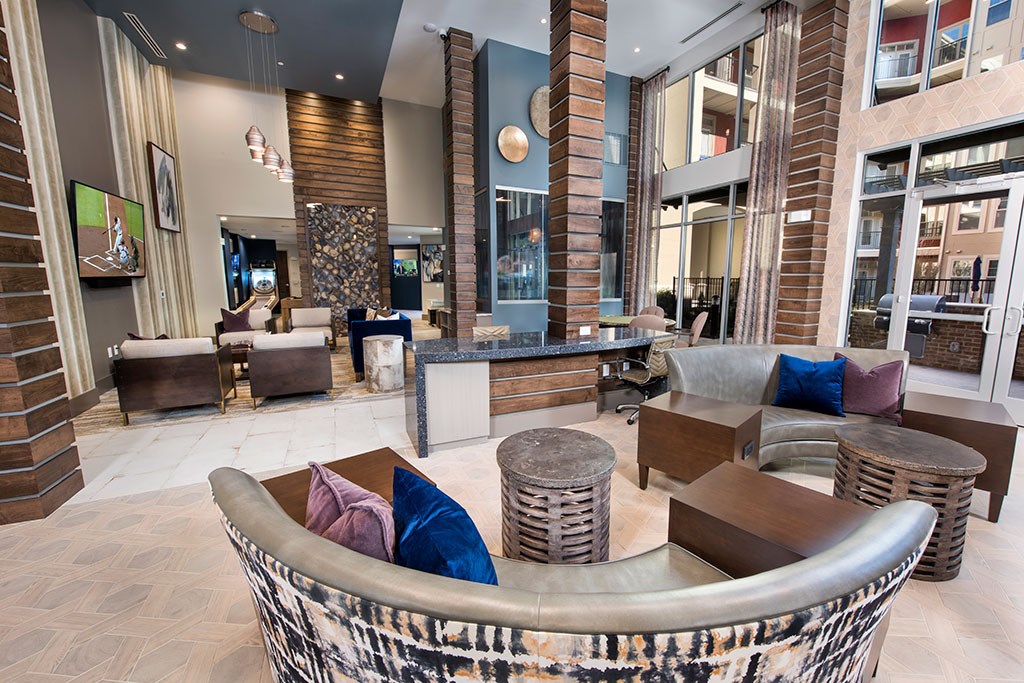 a lobby of a hotel with couches and tables