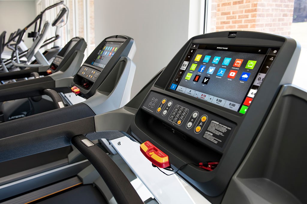 two treadmills in a gym with a tablet on the back
