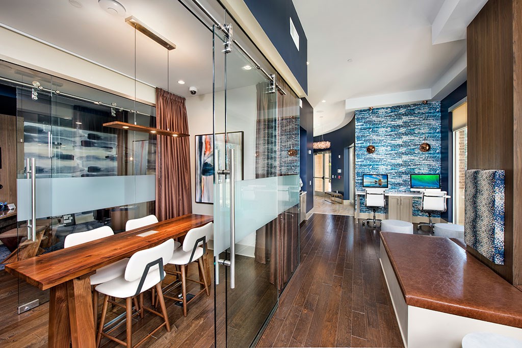 a dining room with a long wooden table and glass walls