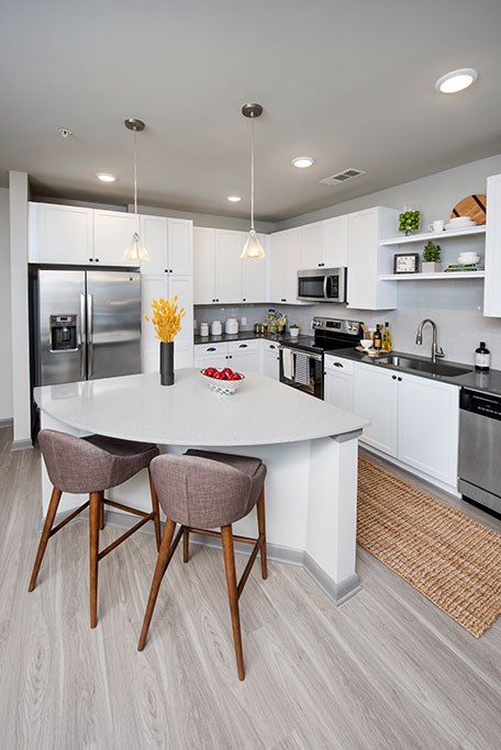 a kitchen with a white island and two chairs