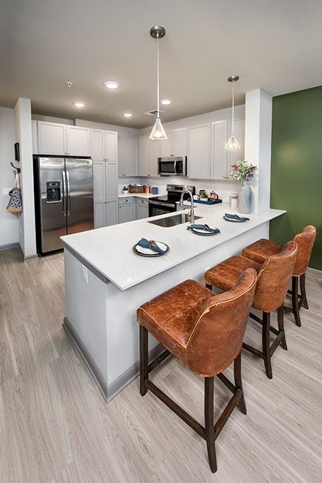 a kitchen with a large island with four chairs