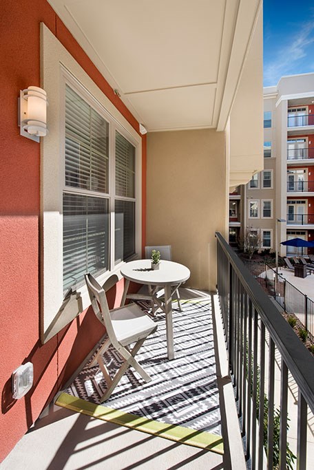 a balcony with a table and chairs on a balcony