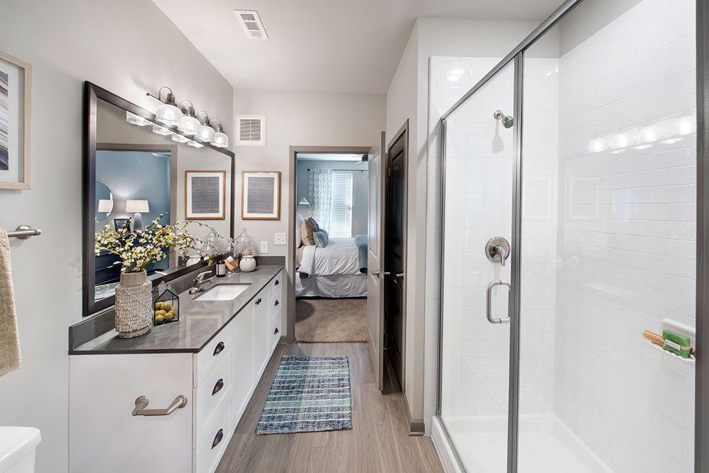 a bathroom with a shower and a sink and a mirror