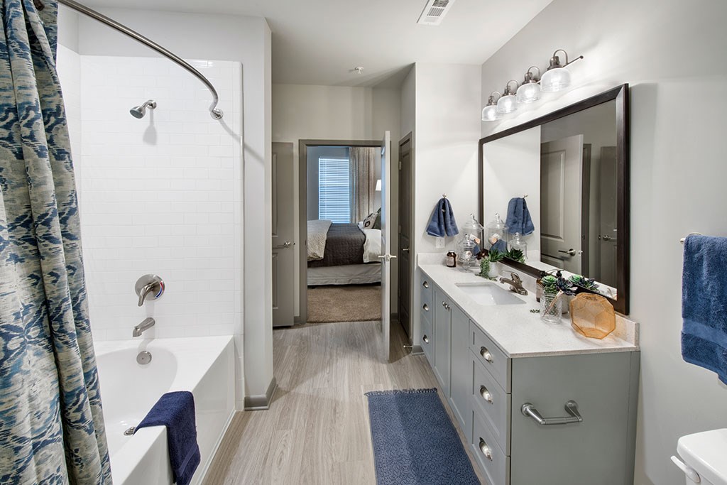 a bathroom with a shower and a sink and a mirror