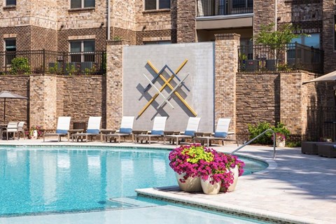 a swimming pool with chairs and a vase of flowers