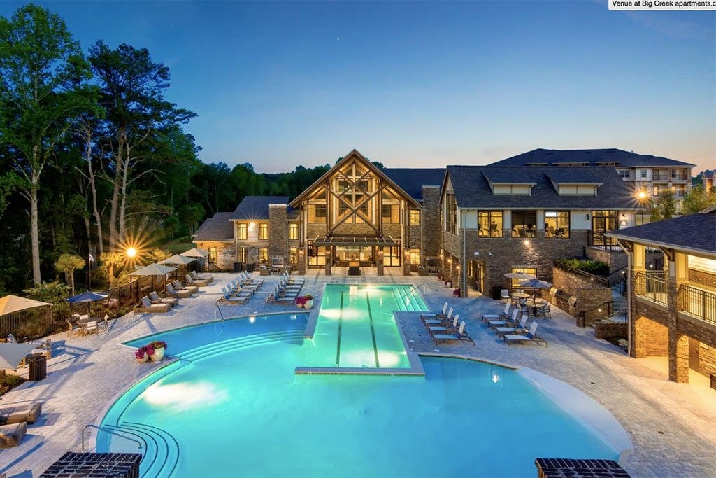 a large swimming pool in front of a hotel at night
