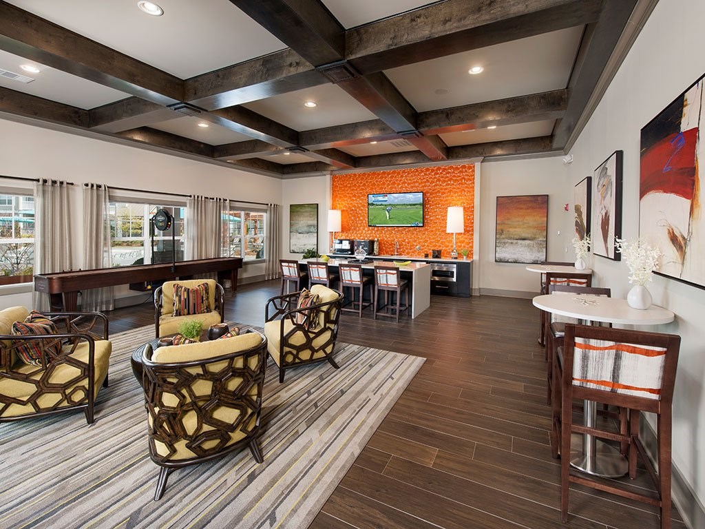 a clubhouse with a bar and chairs and a living room