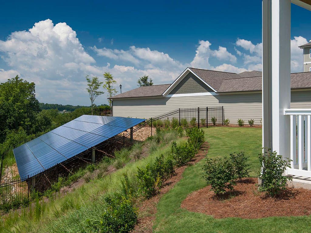 a view of a house with a solar panel in the yard
