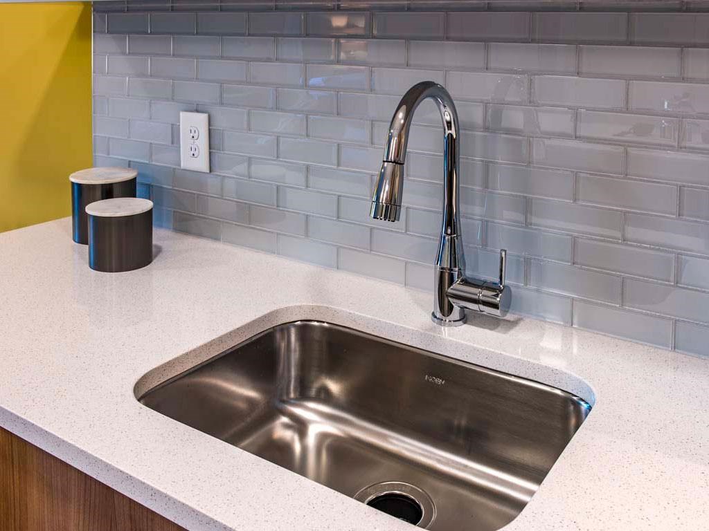 Close-up of kitchen sink and faucet with tile backsplash