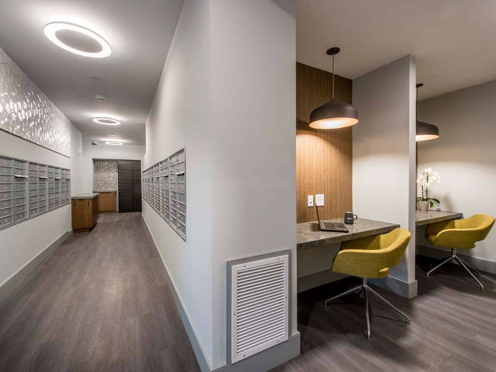 Mail center with mail boxes and built-in workspaces with chairs