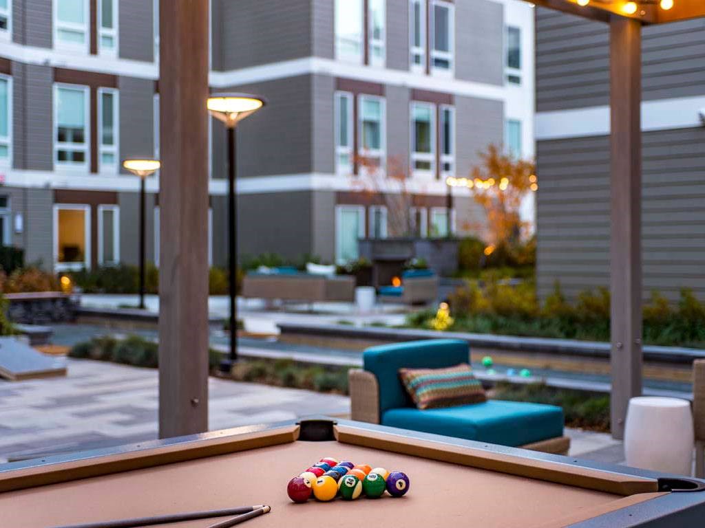 Dusk view of outdoor lounge with soft seating and pool table