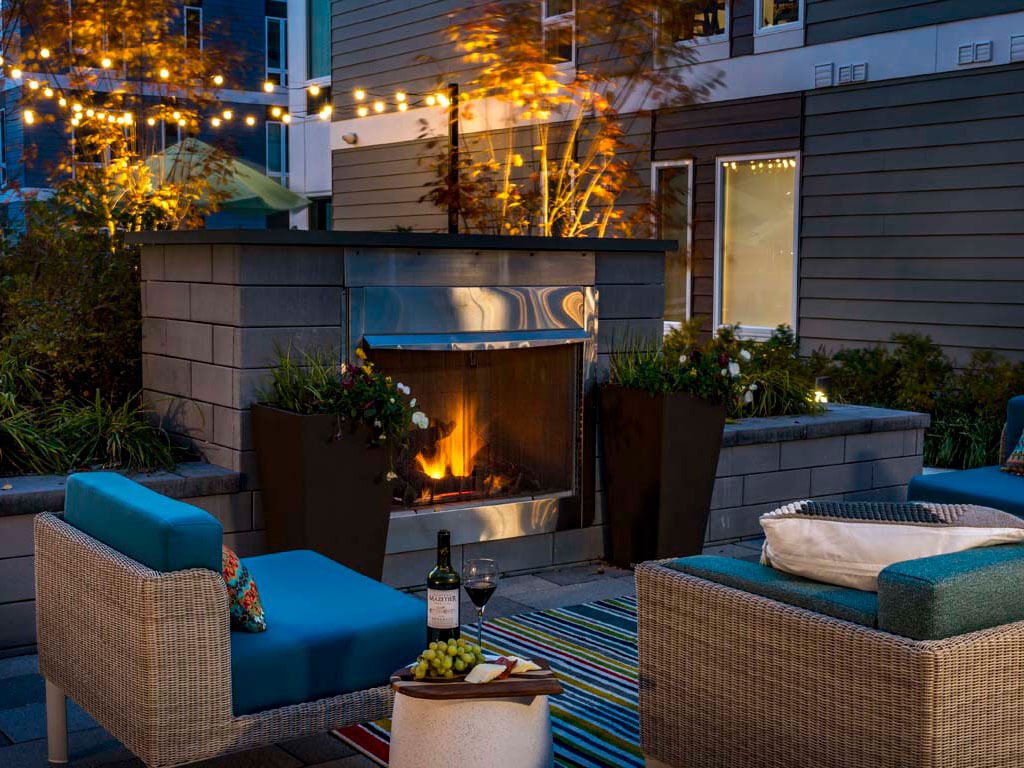 Outdoor lounge with fireplace at dusk