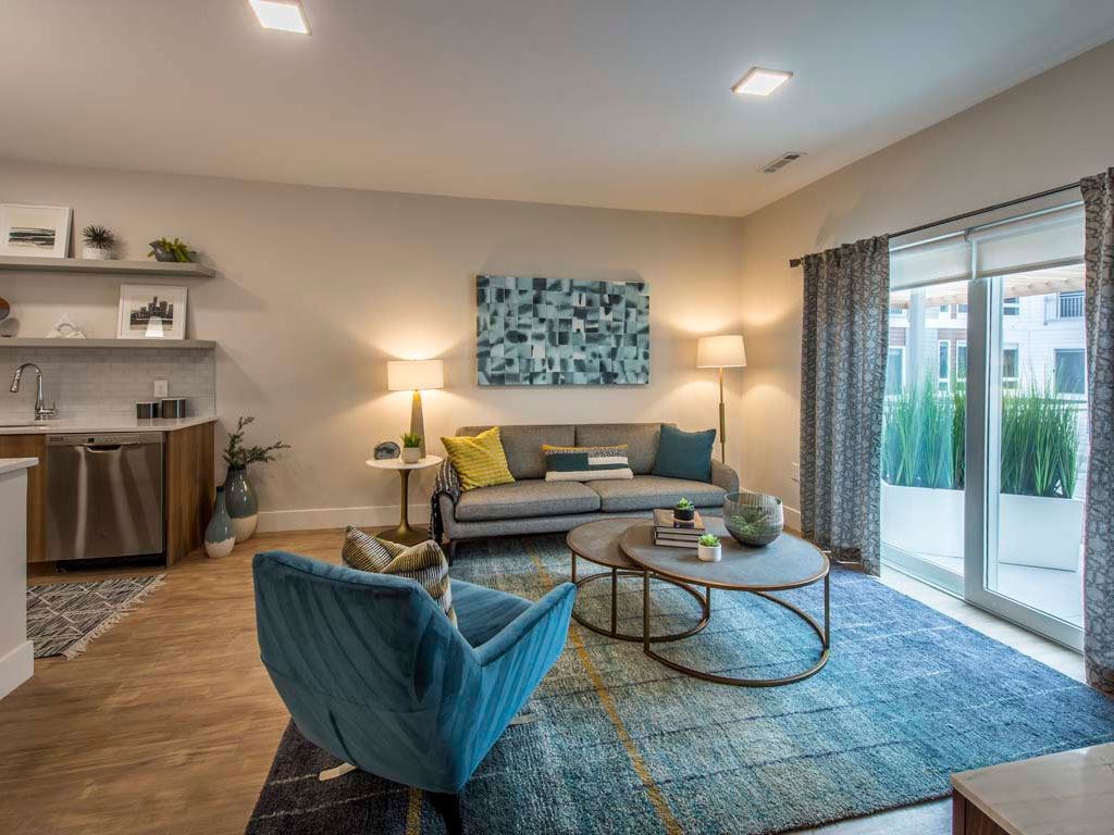 Open living room space with large windows, couch, chair and coffee table