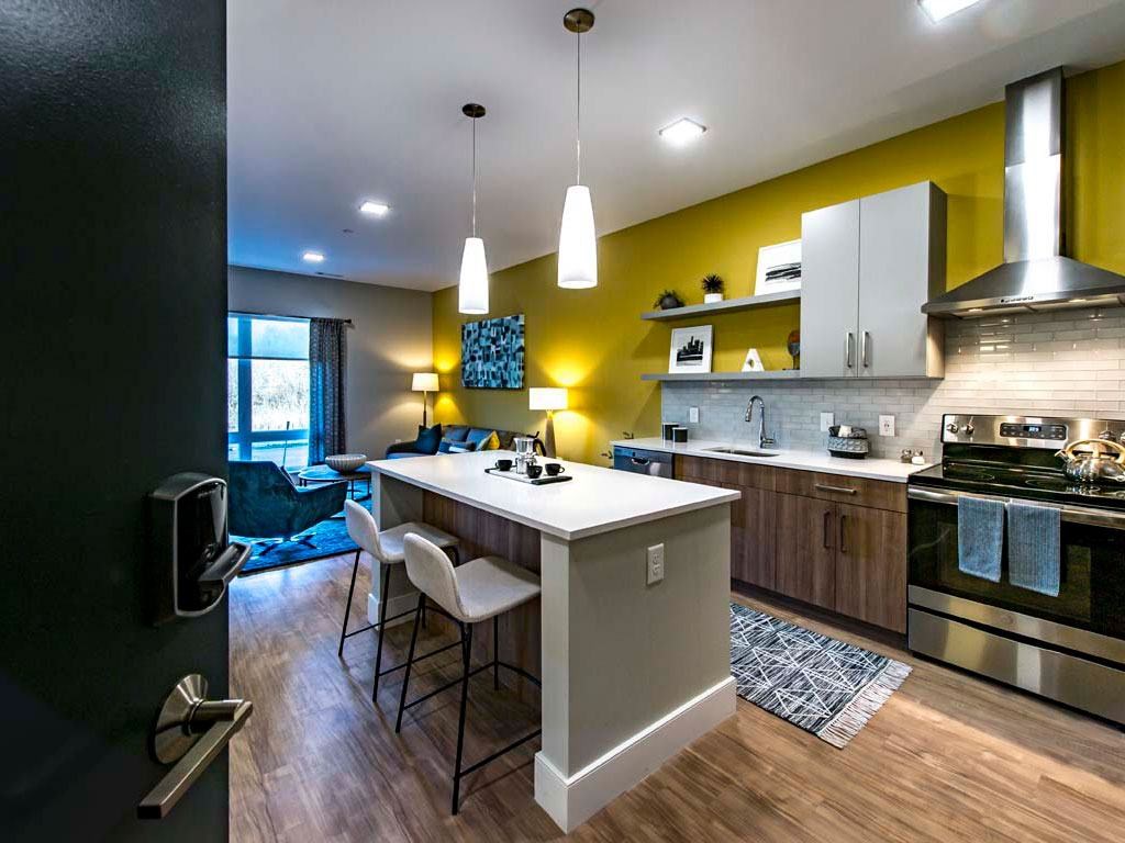 View of kitchen from entry door with living room in background