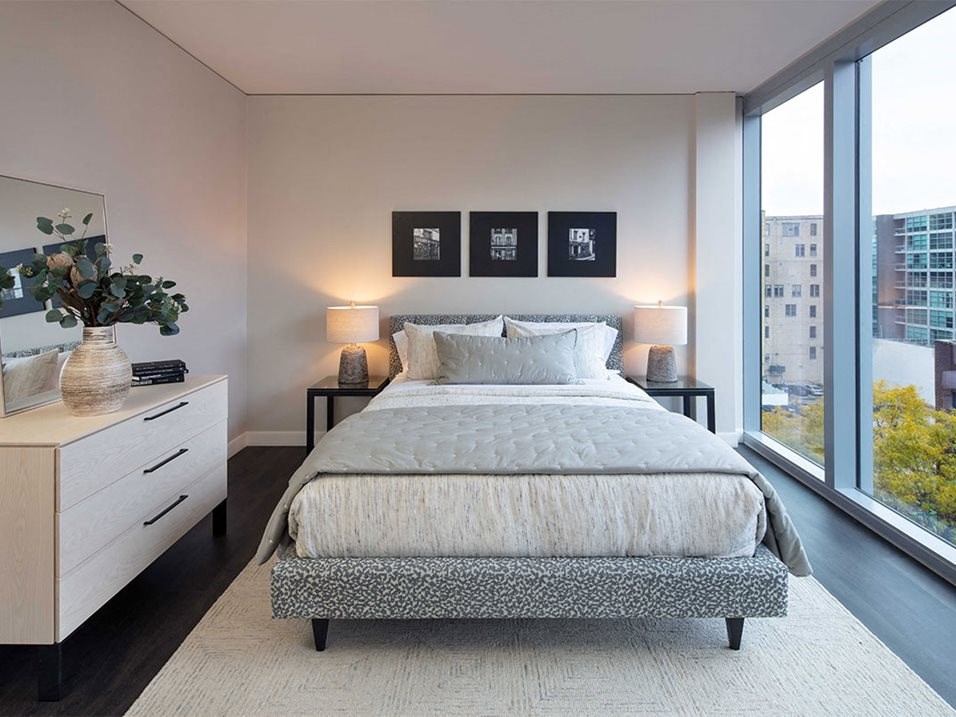 a bedroom with a bed and a large window