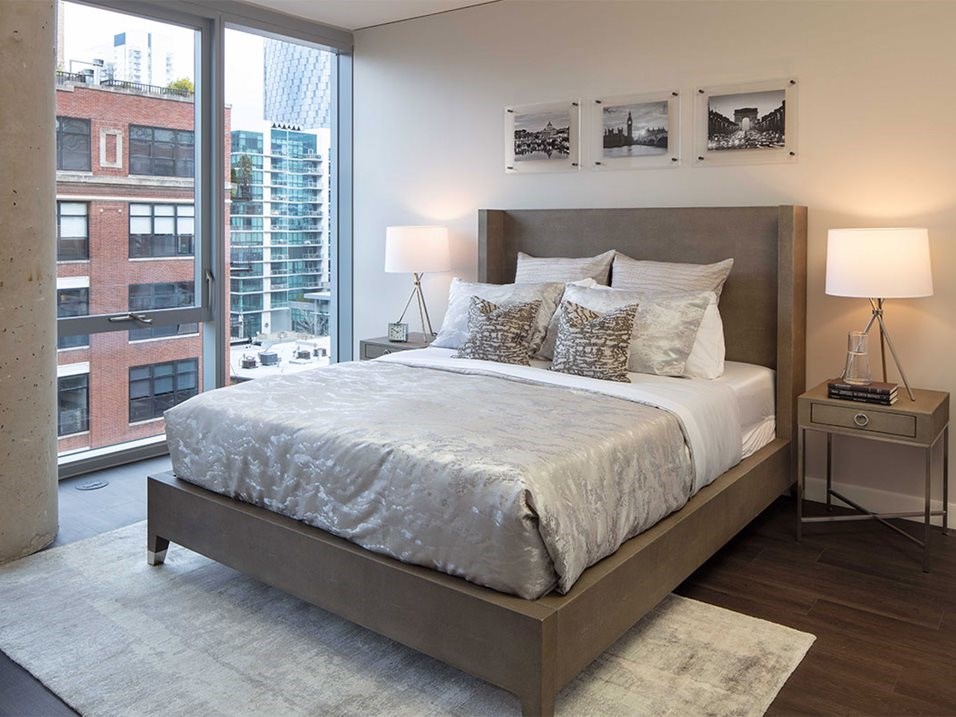 a bedroom with a bed and a large window