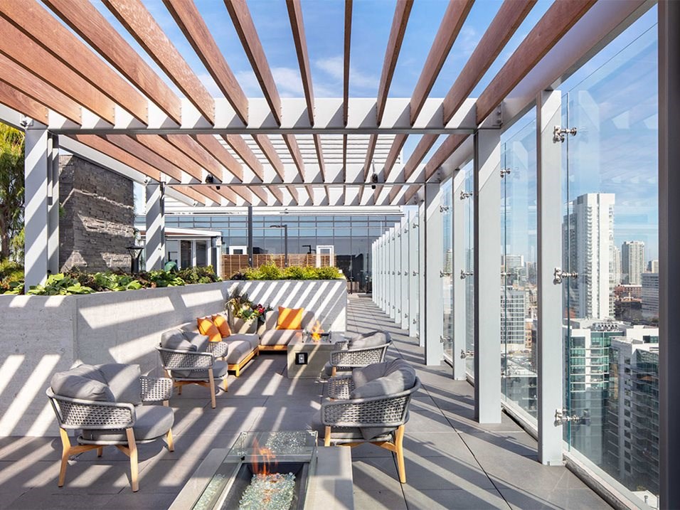 a rooftop terrace with tables and chairs and a view of the city