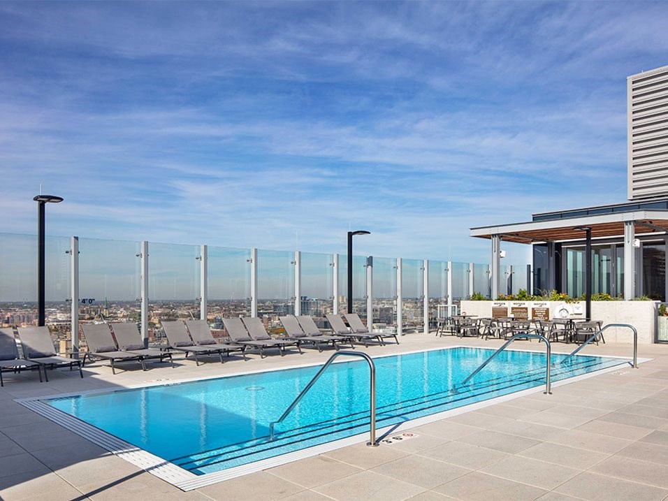 a swimming pool on the rooftop of a building with a blue sky