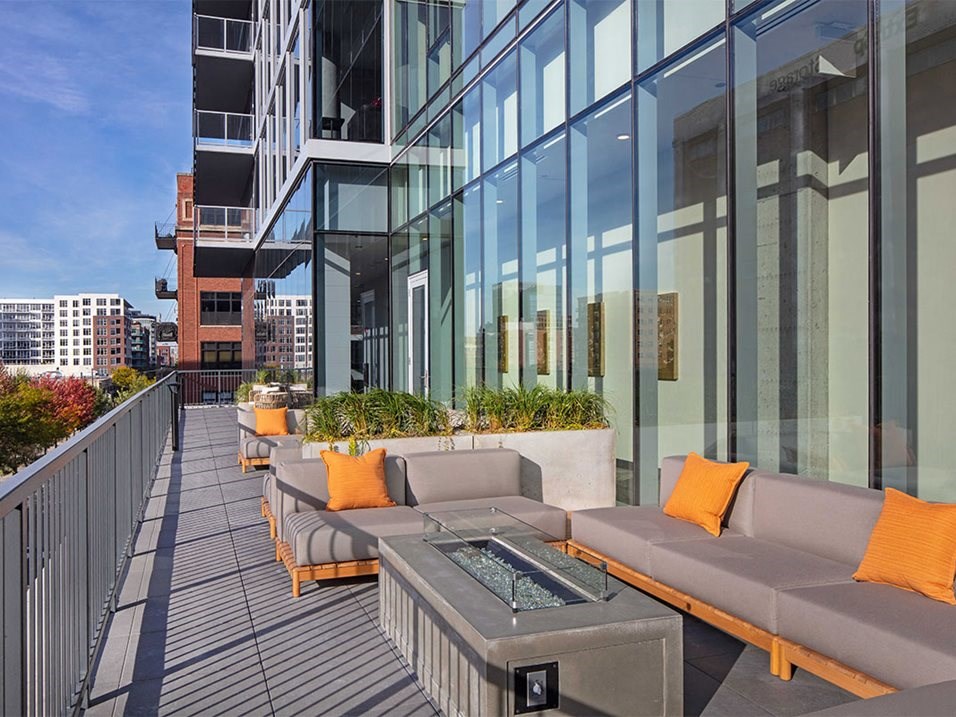 a rooftop patio with couches and a fire pit