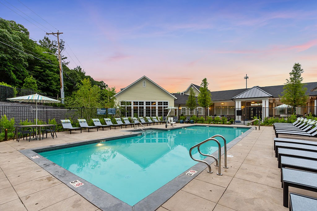 View of pool at dusk with lounge seating
