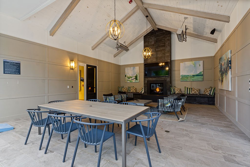 Covered outdoor patio with dining stables and fireplace