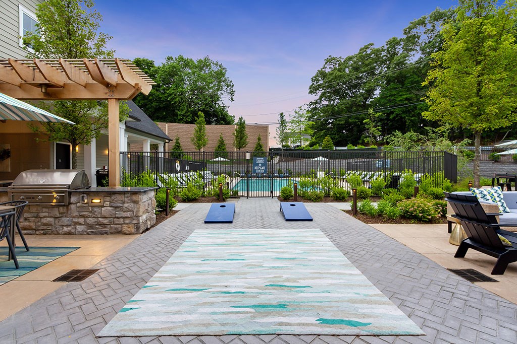 Outdoor patio with outdoor games, soft seating, grilling station and pool