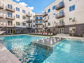 Sparkling resort style swimming pool with cushioned lounge chairs - Photo Gallery 2