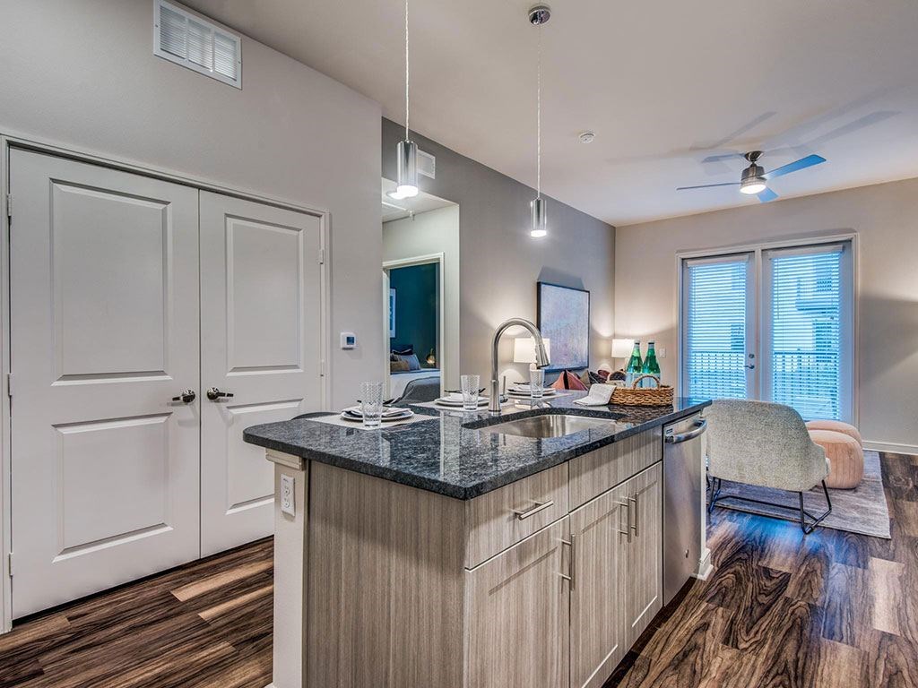 Granite counter tops, stainless appliance package, medium brown cabinets, plank wood-style flooring, island seating, abundant cabinet and pantry space