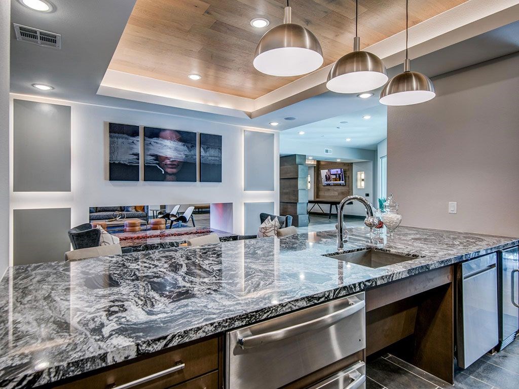Granite counter tops, stainless appliance package, medium brown cabinets, plank wood-style flooring, island seating, abundant cabinet and pantry space