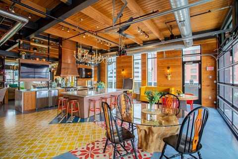 the kitchen and dining area of a loft with a table and chairs