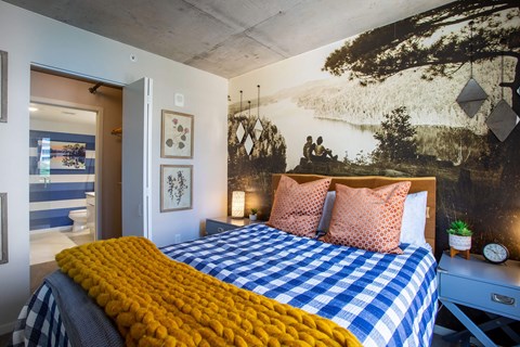 a bedroom with a bed and a mural on the wall