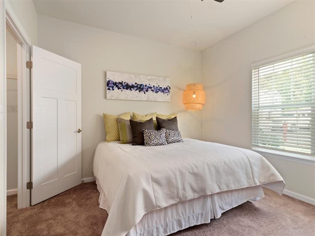 a bedroom with a bed and a window