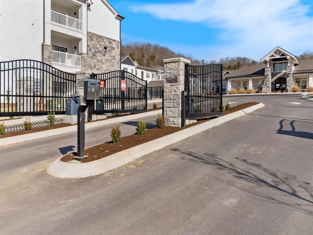 the entrance to a building with a gated driveway and a street
