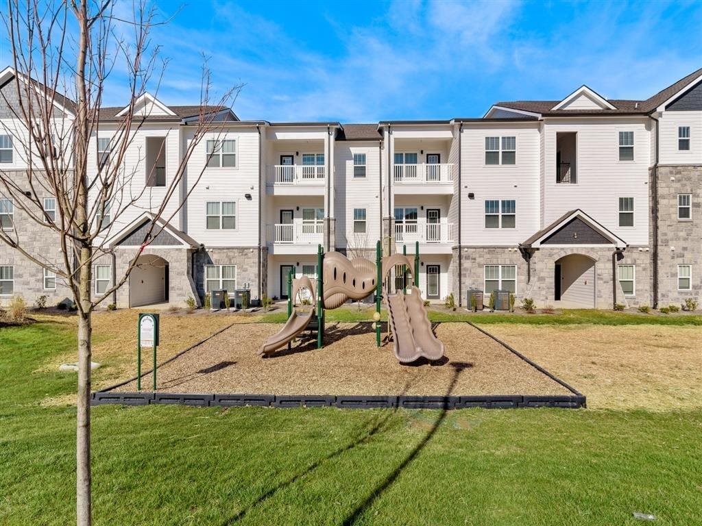 an empty playground in front of an apartment building