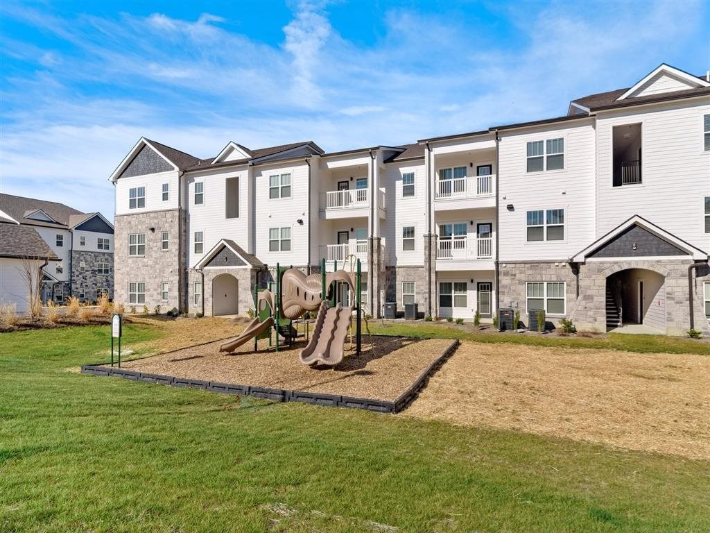 an outdoor playground in front of an apartment building