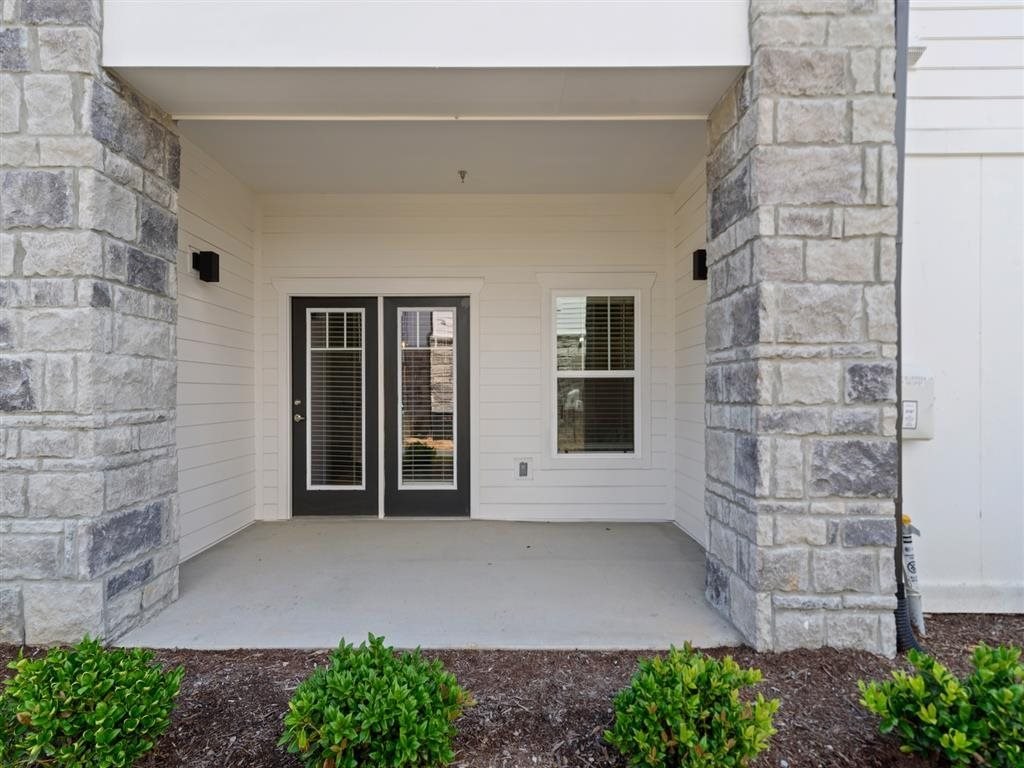 the front porch of a white house with glass doors