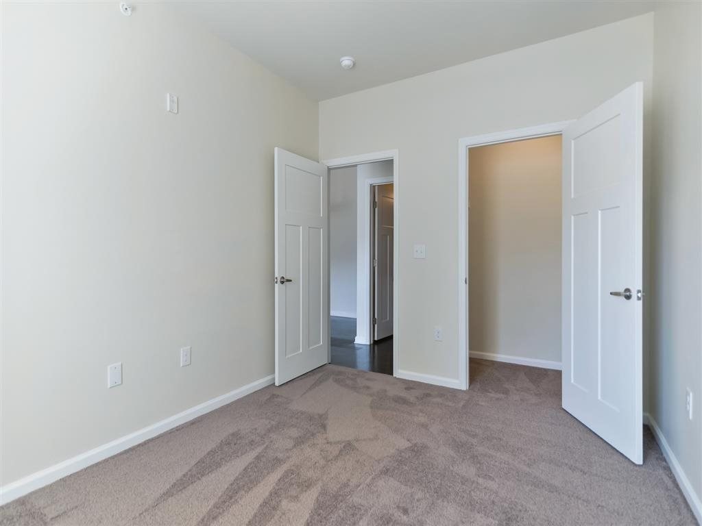 a bedroom with two doors and a carpeted floor