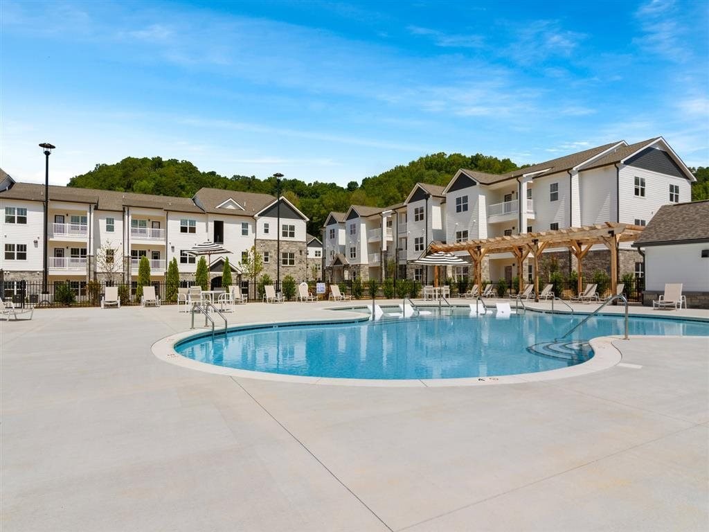 an empty pool with apartment buildings in the background