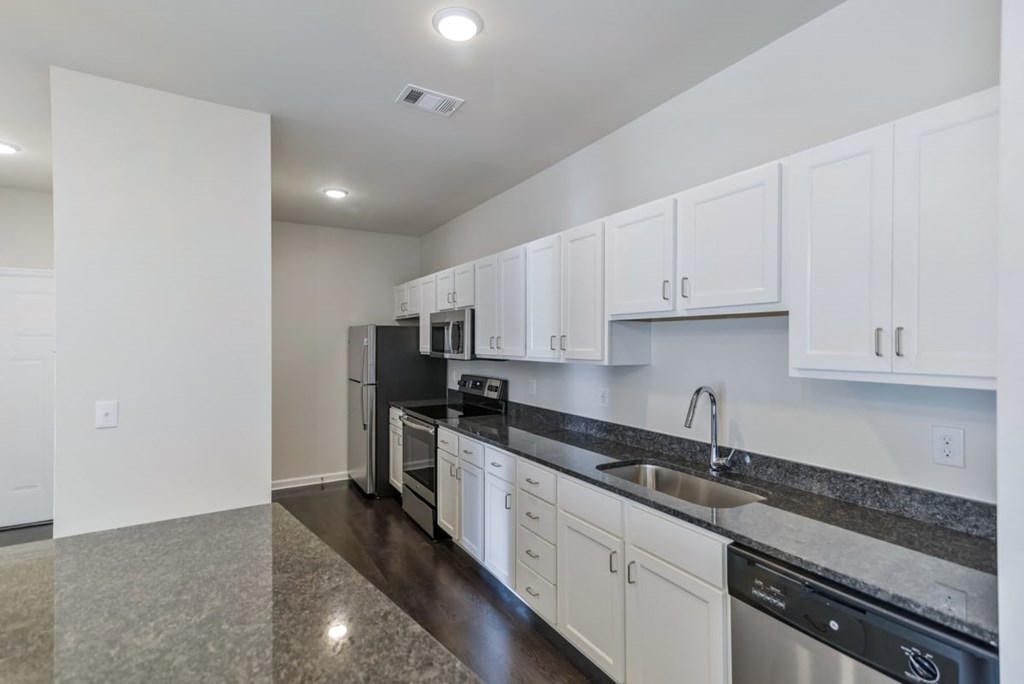 Ashland Farms Galley Style Kitchen with Full Set of Stainless Steel Appliances and Modern White Cabinetry