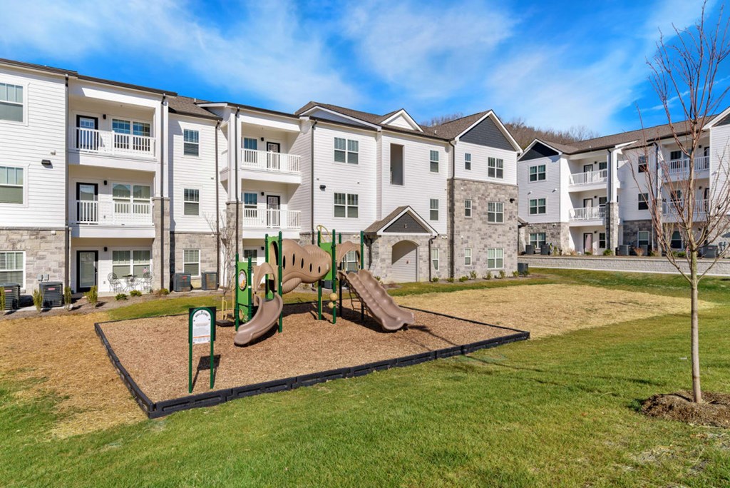 a playground with a slide in front of an apartment building